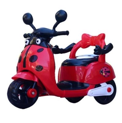 Des enfants montent sur une moto électrique en plastique avec des lumières et de la musique